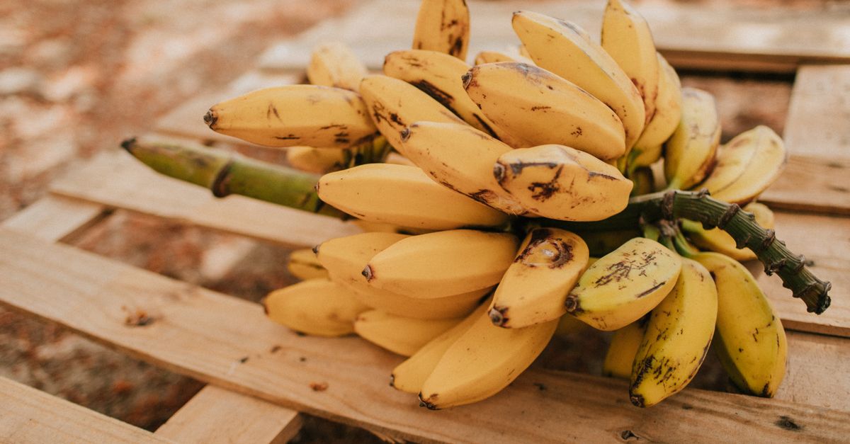 Kiść dojrzałych bananów leżąca na drewnianej powierzchni.