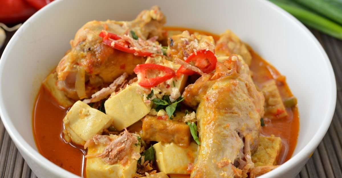 Miska pikantnego curry z kurczakiem, tofu i plasterkami czerwonej papryczki chili w gęstym sosie.